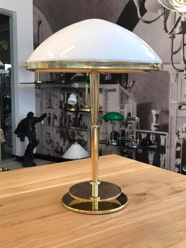 Die Leuchte steht auf einem doppelt abgestuften, runden Sockel aus massivem Messing, dessen polierte Oberfläche warm schimmert und dem Entwurf eine repräsentative Ausstrahlung verleiht.